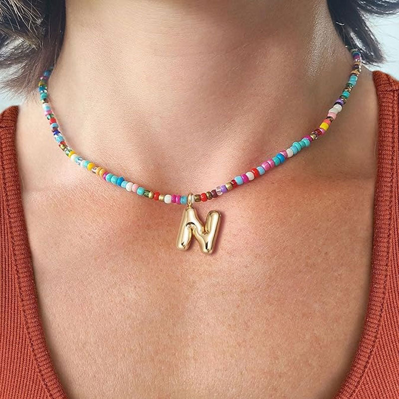 Initialhalsband med pärlor